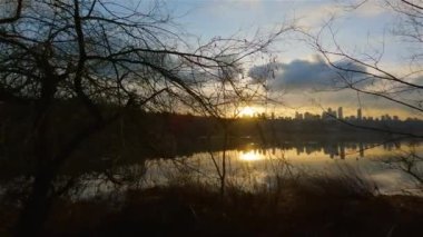 Modern şehir Deer Lake Park 'ta Peaceful Lake' in patikası. Burnaby, Vancouver, BC, Kanada. Renkli Kış Günbatımı Gökyüzü. Slow Motion Sinematik Pan.