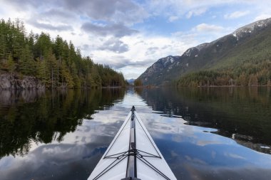 Kanada Dağ Peyzajı ile sakin suda kano yapmak. Vancouver 'daki Buntzen Gölü, British Columbia, Kanada.