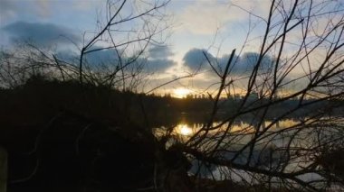 Trail by Peaceful Lake in the modern city, Deer Lake Park. Burnaby, Vancouver, BC, Canada. Colorful Winter Sunset Sky. Slow Motion Cinematic Pan.
