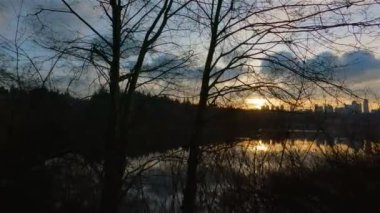 Trail by Peaceful Lake in the modern city, Deer Lake Park. Burnaby, Vancouver, BC, Canada. Colorful Winter Sunset Sky. Slow Motion Cinematic Pan.