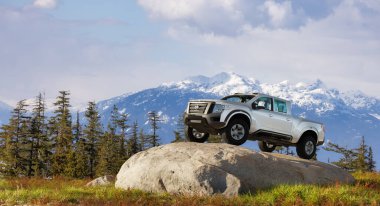 British Columbia, Kanada - 22 Mart 2023 Nissan Titan kamyonet arka planda Kanada Dağ manzaralı açık hava. 3D Rending Araç ve Kaya. 3d Görüntü.