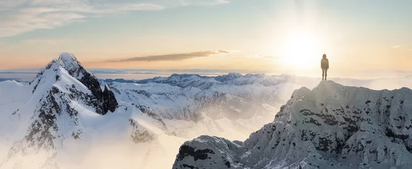 여행자는 얼음으로 뒤덮인 봉우리 꼭대기에서 바위투성이 의산들을 배경으로 어드벤처 뒤집어 — 스톡 사진