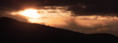Dağ siluetinde ağaç tepesi. Dramatik Bulutlu Gün Batımı. Bowen Adası, Howe Sound, British Columbia, Kanada.