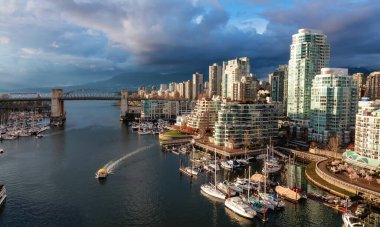 Aerial View of Granville Island in False Creek with modern city skyline and mountains in background. Downtown Vancouver, British Columbia, Canada. Sunset Sky clipart