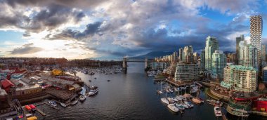 False Creek 'teki Granville Adası' nın panoramik hava manzarası modern şehrin silueti ve arka planında dağlar. Vancouver şehir merkezi, British Columbia, Kanada. Günbatımı Gökyüzü