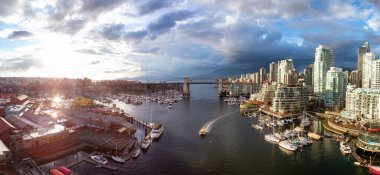 False Creek 'teki Granville Adası' nın panoramik hava manzarası modern şehrin silueti ve arka planında dağlar. Vancouver şehir merkezi, British Columbia, Kanada. Günbatımı Gökyüzü