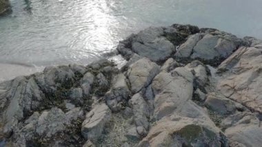 Indian Arm, Vancouver, British Columbia, Kanada 'da kayalık bir sahilde tahta iskele. Belcarra İskelesi, Pasifik Okyanusu 'nun batı kıyısı. Bahar mevsimi güneşli bulutlu bir akşam. Yavaş Hareket