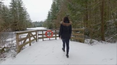 Rice Gölü 'nün yanında, beyaz karla ormanda yürüyüş yapan maceraperest kadın. Kuzey Vancouver, British Columbia, Kanada. Kış Sezonu