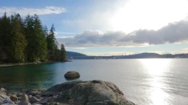 Indian Arm, Vancouver, British Columbia, Kanada sahiline park et. Belcarra İskelesi, Pasifik Okyanusu 'nun batı kıyısı. Bahar mevsimi güneşli bulutlu bir akşam. Yavaş Hareket