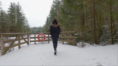Rice Gölü 'nün yanında, beyaz karla ormanda yürüyüş yapan maceraperest kadın. Kuzey Vancouver, British Columbia, Kanada. Kış Sezonu