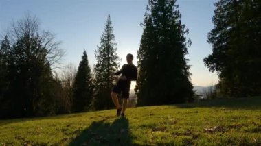Yetişkin adam parkta dövüş sanatları ve kickboks yapıyor. Sağlık ve Spor Konsepti. Burnaby Dağı, Vancouver, British Columbia, Kanada.