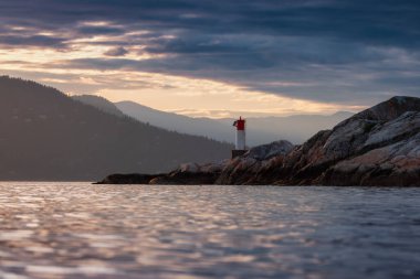 Arka planda Dağ Manzaralı Rocky Adası. Dramatik Günbatımı. Horseshoe Körfezi, Batı Vancouver, British Columbia, Kanada.