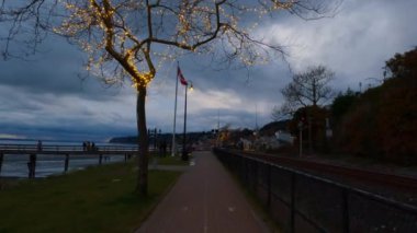 Rocky Sahili 'ndeki yürüyüş yolu ve Pasifik Okyanusu' nun batı kıyısındaki White Rock İskelesi. Dramatik Bulutlu Günbatımı Gökyüzü. Vancouver, British Columbia, Kanada.