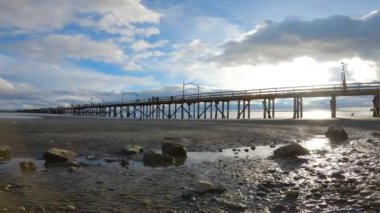 White Rock, Vancouver, British Columbia, Kanada - 10 Nisan 2023: Rocky Beach ve White Rock Pier Pasifik Okyanusunun batı kıyısında. Dramatik Bulutlu Gün Batımı Gökyüzü