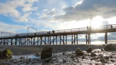 White Rock, Vancouver, British Columbia, Kanada - 10 Nisan 2023: Rocky Beach ve White Rock Pier Pasifik Okyanusunun batı kıyısında. Dramatik Bulutlu Gün Batımı Gökyüzü