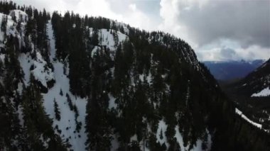 Kanada 'nın karla kaplı dağ manzarasının üzerinde uçan hava. British Columbia, Kanada. Dinamik Sinema