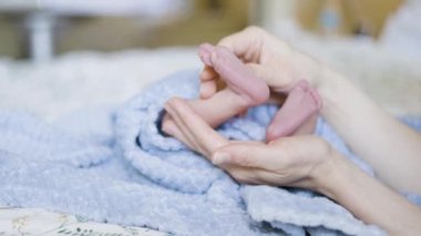 Küçük Ayaklar, Yakın Çekim. Masaj. Anne kucağında bebek. Yavaş Hareket.