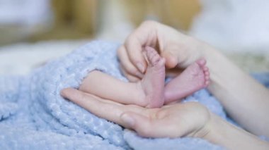 Küçük Ayaklar, Yakın Çekim. Masaj. Anne kucağında bebek. Yavaş Hareket.