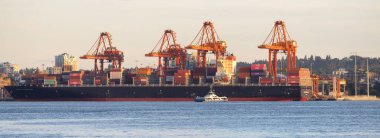 Vancouver, BC, Kanada - 16 Haziran 2023: Vancouver Limanı 'ndaki gemi, konteyner ve vinç ve arka plandaki şehir.