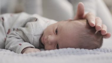 Yeni doğan sevimli bebek battaniyeye uzanıyor. Slow Motion Sineması Kapat.