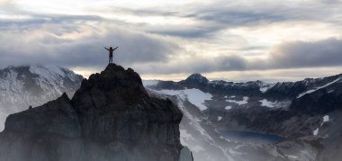 Maceracı Kadın Dağ Kayalıkları 'nın tepesinde duruyor. Extreme Adventure Composite. 3D Rending Peak. British Columbia, Kanada 'dan Arkaplan Hava Görüntüsü.