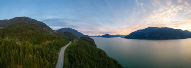 Okyanus kıyısında dağ manzaralı manzaralı bir otoban. Denizden Sky Hwy 'ye, Vancouver' ın kuzeyi, BC, Kanada. Hava görüntüsü. Gün batımı