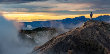 Maceracı Adam Dağ Kayalıkları 'nın tepesinde duruyor. Extreme Adventure Composite. 3D Rending Peak. British Columbia, Kanada 'dan Arkaplan Hava Görüntüsü.