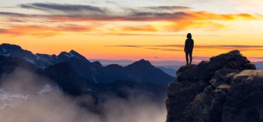 Maceracı Kadın Dağ Kayalıkları 'nın tepesinde duruyor. Extreme Adventure Composite. 3D Rending Peak. British Columbia, Kanada 'dan Arkaplan Hava Görüntüsü.