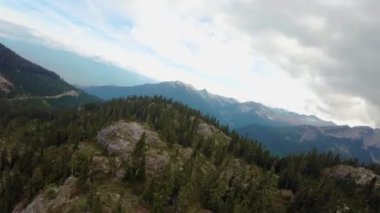 Dağ manzarasında yeşil çayırlar. Hava görüntüsü. Doğada Uçan Dinamik. British Columbia, Kanada. Bulutlu Gün Batımı.
