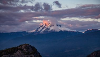 Dağ Zirvesi bulutlar ve karla kaplı. Dramatik Günbatımı Gökyüzü. Hava Doğası Arkaplanı. Squamish, BC, Kanada.