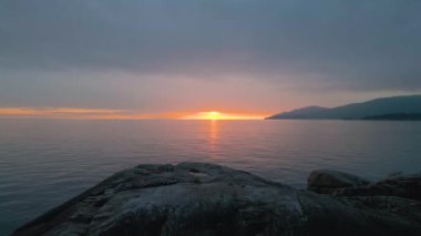 Pasifik Okyanusu kıyısındaki Rocky sahili. Bulutlu Günbatımı. Deniz Feneri Parkı, Batı Vancouver, İngiliz Kolombiyası, Kanada.
