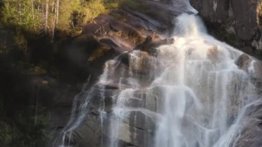 Kayalardan çağlayan şelale. Gün batımı. Shannon Falls, Squamish, BC, Kanada. Doğa Arkaplanı. Yavaş Hareket