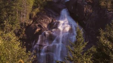 Kayalardan çağlayan şelale. Gün batımı. Shannon Falls, Squamish, BC, Kanada. Doğa Arkaplanı. Yavaş Hareket