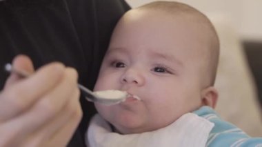 Baby Boy evde bir kaşıkla katı yiyecekler besliyordu. Ağır çekimde kapat.
