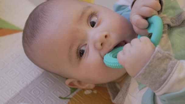可爱的男婴正在客厅里咀嚼家中的玩具 弹奏垫子慢动作高质量的4K镜头 — 图库视频影像
