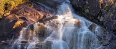 Kayalardan çağlayan şelale. Gün batımı. Shannon Falls, Squamish, BC, Kanada. Doğa Arkaplan Panoraması.