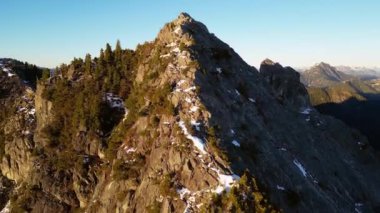 Karla kaplı Rocky Dağı zirvesi. Güneşli Günbatımı. Havadan. British Columbia, Kanada.