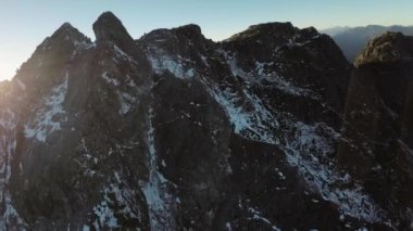 Karla kaplı Rocky Dağı zirvesi. Güneşli Günbatımı. Havadan. British Columbia, Kanada.