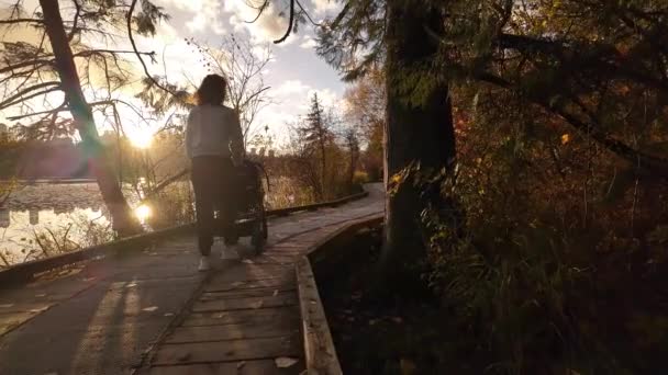 ディア湖の路上でコントローラーと一緒に歩く母 バーナビー Bcカナダ 秋のシーズン サニー サンセット スローモーション 高品質の4K映像 — ストック動画