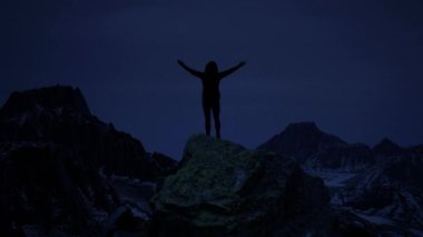 Kolları havada bir kadın dramatik fırtına sırasında gecenin zirvesinde dikiliyor. Üç boyutlu görüntüleme. Yüksek kalite 4k görüntü