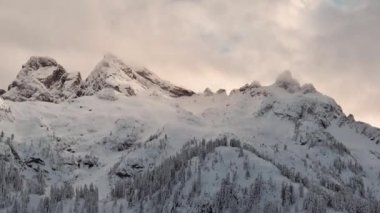Taze karla kaplı Dağ Tepeleri. Kanada Peyzajı. Bulutlu, Kış Zamanı. Dramatik Günbatımı. Yüksek kalite 4k görüntü