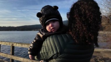 Anne, Sunny Fall Günü 'nde şirin bebeği iskelede tutuyor. Batı Yakası, Belcarra. Vancouver, British Columbia Kanada. Yüksek kalite 4k görüntü