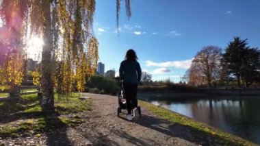 Anne, Stanley Park 'ta Bebekle Bebekleri Seawall' da gezdiriyor. Güneşli bir gün, sonbahar sezonu. Vancouver, British Columbia, Kanada