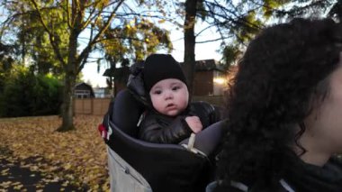Annem Taşıyıcı Bebek 'le banliyö mahallesinde yürüyor. Sonbahar sezonu. Burnaby, Vancouver, BC Kanada. Yüksek kalite 4k görüntü