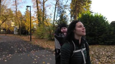 Annem Taşıyıcı Bebek 'le banliyö mahallesinde yürüyor. Sonbahar sezonu. Burnaby, Vancouver, BC Kanada. Yüksek kalite 4k görüntü