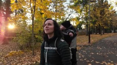 Annem Taşıyıcı Bebek 'le banliyö mahallesinde yürüyor. Sonbahar sezonu. Burnaby, Vancouver, BC Kanada. Yüksek kalite 4k görüntü