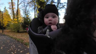 Annem Taşıyıcı Bebek 'le banliyö mahallesinde yürüyor. Sonbahar sezonu. Burnaby, Vancouver, BC Kanada. Yüksek kalite 4k görüntü