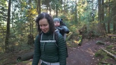 Sırt çantasındaki bebekle Kanada doğasında doğa yürüyüşü. Güneşli Sonbahar Günü, Orman. Lynn Vadisi, Kuzey Vancouver, BC Kanada. 