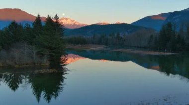 Kanada doğasında dağlar ve ağaçlarla çevrili bir göl. Sonbahar sezonu, Günbatımı Gökyüzü. Squamish, İngiliz Kolombiyası Kanada.
