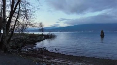 Okyanus kıyısında bir şehir parkında Rocky Shore. Günbatımı Gökyüzü. Barnet Marine Park, Burnaby, Vancouver, BC, Kanada. Yavaş çekim